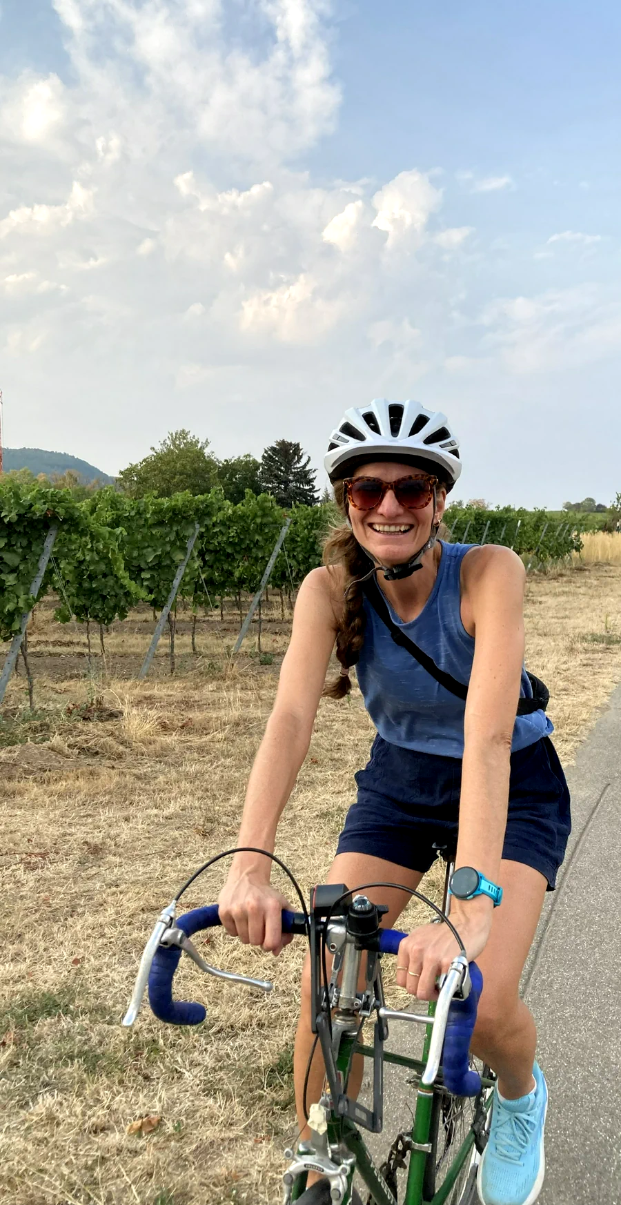 Radfahrerin auf einem Weg zwischen Weinreben